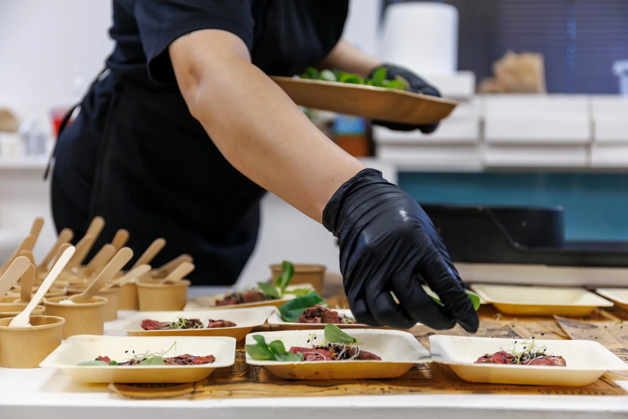 Chef préparant des plats avec des gants noirs